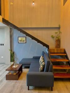 a living room with a blue couch and a staircase at Suites Hermosas cercanas a todo in Puerto Ayora