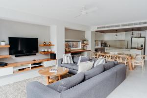 a living room with a couch and a table at KoKos Beach House 3 in Byron Bay