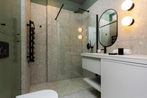 La salle de bains est pourvue d'une douche, d'un lavabo et d'un miroir. dans l'établissement Warszawa Bohema Szwedzka Apartment by Renters, à Varsovie