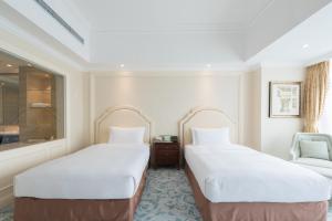 Postel nebo postele na pokoji v ubytování Qingdao Jianxin International Hotel