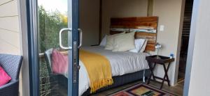 a bedroom with a bed and a sliding glass door at Oriole Serene Self Catering Studio in George