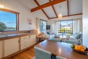 a kitchen and living room with a table and chairs at The Summer Shack - Freycinet Holiday Houses in Coles Bay