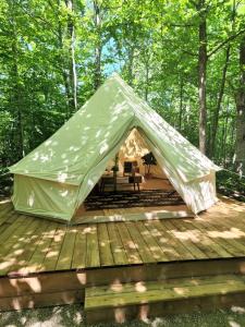 a tent on a deck in the woods at Grotto Getaway in Miller Lake