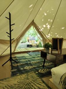 a tent with a bed and a table in a room at Grotto Getaway in Miller Lake
