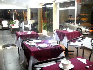 a restaurant with two tables and a car in the window at Hotel Boutique Embajada de la Feria in Bogotá