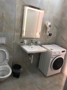 a bathroom with a sink and a washing machine at Sunset Luxury Studios in Radhimë +14 photos