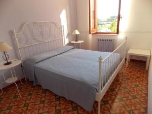 a bedroom with a bed and two tables and a window at Holiday home Mediterraneo in Marsala