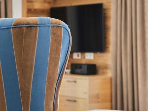 a striped chair with a television in a room at Haus Sonnengruß in Salem