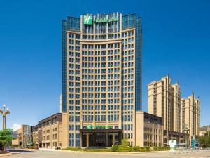 ein hohes Gebäude mit einem Schild darüber in der Unterkunft Holiday Inn Xining Datong, an IHG Hotel in Xining