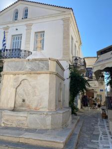a building with a fountain in the middle of a street at Iakovos' Luxury House in Tinos Town