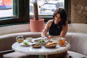 una mujer comiendo comida en una mesa en un restaurante en The Alan, en Mánchester