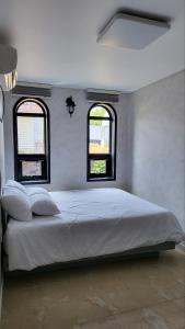 a bedroom with a large bed with two windows at Aewol Coast 34 in Jeju