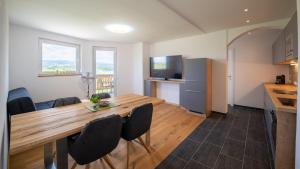 a kitchen and dining room with a wooden table and chairs at Apartments Presslauer - Mori in Sankt Kanzian