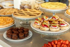 un bufé con pasteles y pasteles y otros postres en los platos en Grand Hotel Spiaggia, en Alassio