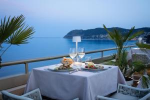 a table with a plate of food and wine glasses at Grand Hotel Spiaggia in Alassio