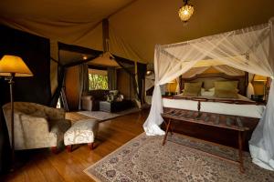 Una cama o camas en una habitación de Elewana Sand River Mara
