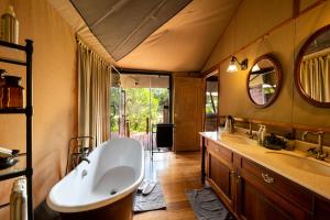 a large bathroom with a tub and two sinks at Elewana Sand River Mara in Talek +51 photos