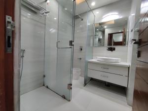 a bathroom with a glass shower and a sink at MOON3BHK By Wabi Sabi Stays in Mussoorie
