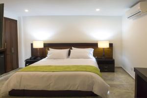 a bedroom with a large bed with two lamps at Hotel Palonegro in Bucaramanga