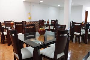 a dining room with a glass table and chairs at Hotel Palonegro in Bucaramanga