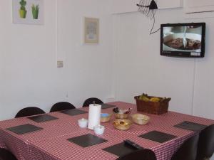 uma mesa com uma toalha de mesa xadrez vermelha e uma televisão em Cedars House Hotel em Croydon
