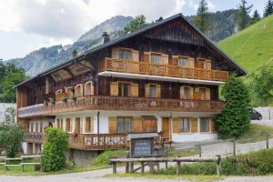 a large wooden building with a sign in front of it at Les Mouflons in La Chapelle-dʼAbondance