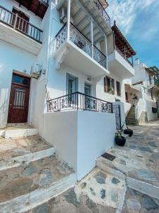 a white building with stairs and a balcony at Evagelias suite in Skopelos Town