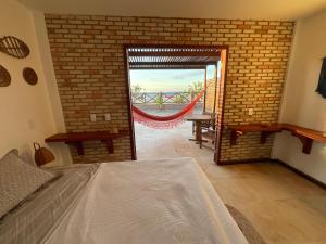 een slaapkamer met een bed en een bakstenen muur bij BEACH HOUSE - Suite 2 - NA PRAIA -BEACHFRONT in Barra Grande