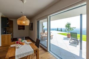a dining room with a table and a large glass door at Greim15 --- Apartment mit Fernsicht und Pool 50m2 in Greim