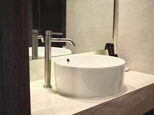 a bathroom with a white sink and a mirror at Hermann Hotel Pattaya - SHA Extra Plus in Pattaya