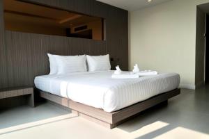 a bedroom with a large bed with white sheets at Hermann Hotel Pattaya - SHA Extra Plus in Pattaya
