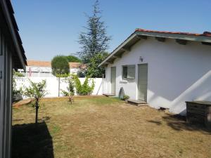 a small yard next to a white house at La Belle Insulaire, Vertbois plage, forêt, vélos, wifi in Dolus d'Oléron