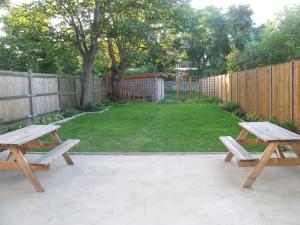 two picnic tables in a backyard with a fence at Cedars House Hotel in Croydon