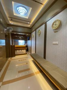 a hallway with a bed and a clock on the wall at Hotel BKC CROWN - Near Trade Centre, Visa Consulate in Mumbai