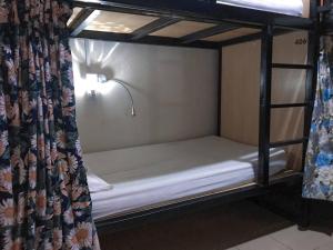 a bunk bed in a room with a curtain at H2 Segama Backpacker in Kota Kinabalu