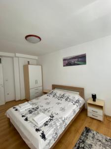 a bedroom with a bed with a black and white blanket at Apartman - stan na dan LENJINKA in Vranje