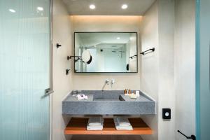 a bathroom with a sink and a mirror at Caravia Beach Hotel in Marmari