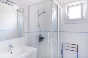une salle de bain blanche avec une douche et un lavabo dans l'établissement Appartement Saint-jean-de-luz, à Saint-Jean-de-Luz