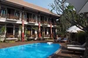 a hotel with a swimming pool in front of a building at Amatalannavillage Chiangmai in Chiang Mai