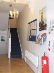 a staircase in a house with a red fire extinguisher at Cedars House Hotel in Croydon