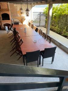 a long wooden table and chairs on a patio at CASA PARASCHIVA in Orşova