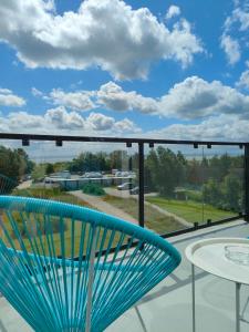 a blue chair sitting on top of a balcony with a view at Apartamenty Mistral in Jastarnia