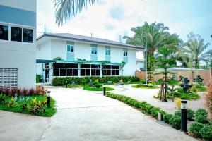 a large white house with a driveway at ONE Chumphon Hotel in Chumphon