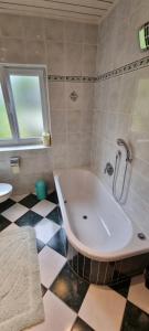 a bathroom with a tub and a checkered floor at Chalet Kultique in Innerschwand am Mondsee +37 photos