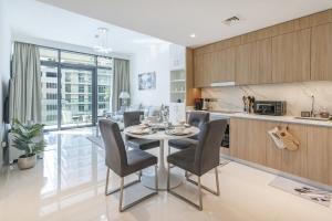 a kitchen and dining room with a table and chairs at Beach Vista Tower 1 - 1BR Apartment - Allsopp&Allsopp in Dubai