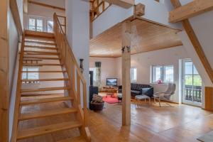 Gailtal Appartements Nähe Skigebiet في Wertschach: غرفة معيشة مع درج خشبي وغرفة معيشة
