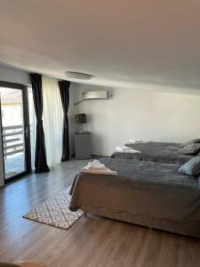 een slaapkamer met een groot bed en een houten vloer bij CASA PARASCHIVA in Orşova