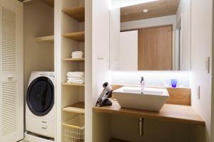 a bathroom with a sink and a washing machine at BEB5 Okinawa Seragaki by Hoshino Resorts in Onna