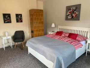 Un dormitorio con una cama con almohadas rojas y una silla en Domcek pri Medokysi, en Liptovský Mikuláš