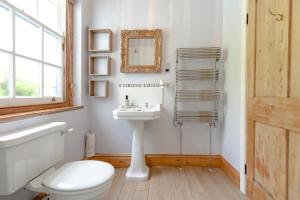 a white bathroom with a toilet and a sink at The Old Coastguard Station in Falmouth +42 photos